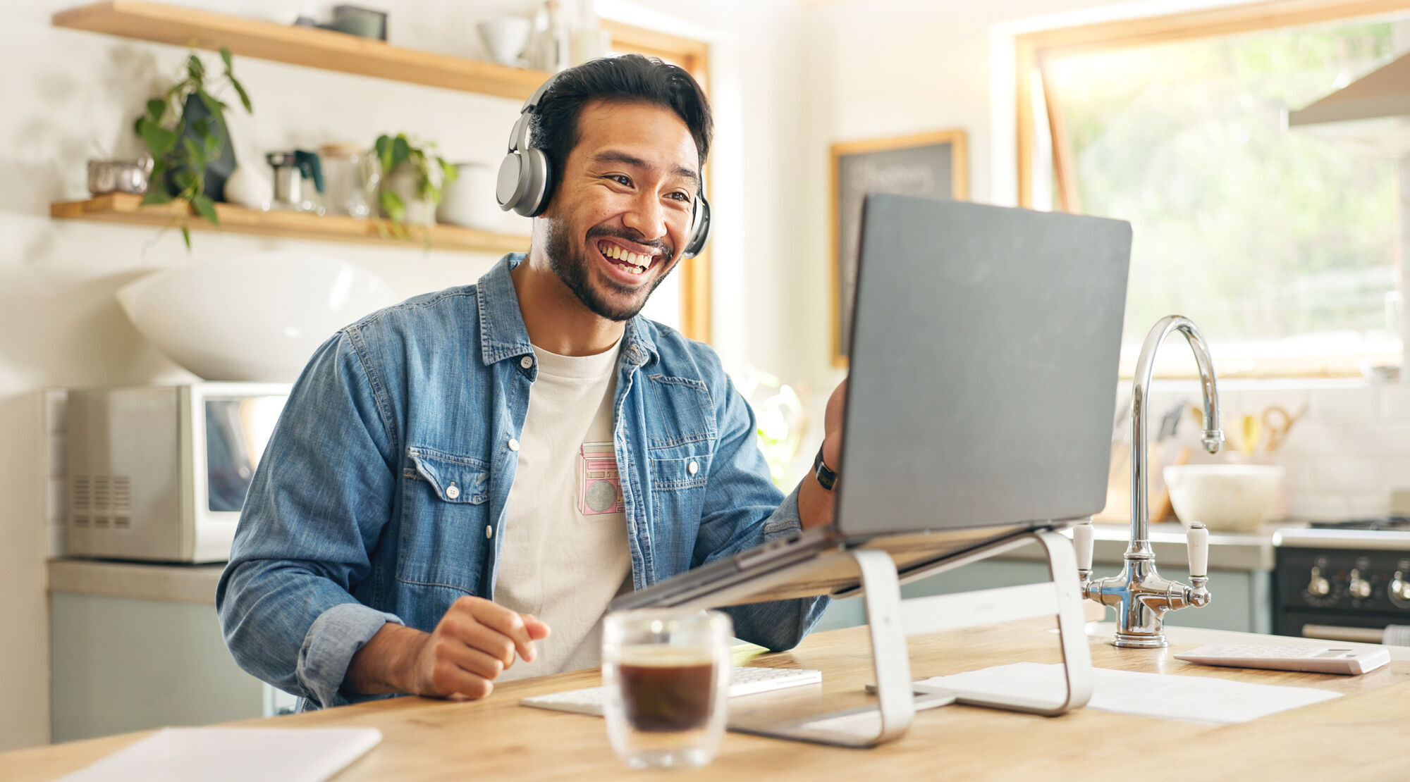 man with headphones on making a video call on a laptop